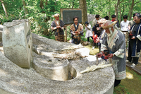 上川アイヌの長・クーツンクレの碑に祈るアイヌ民族の写真