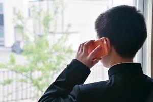 電話をかける中学生の写真