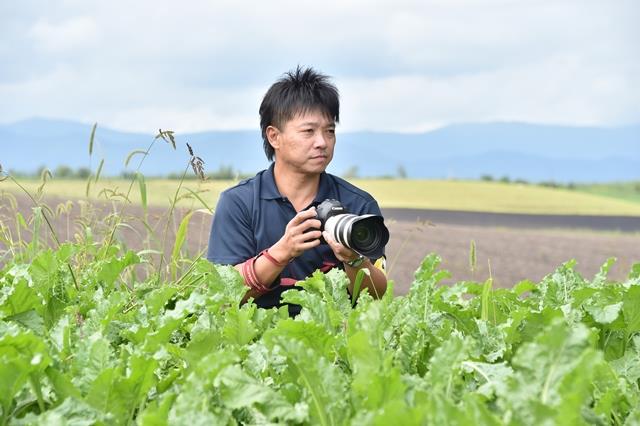 カメラを構える伊東隼さんの写真