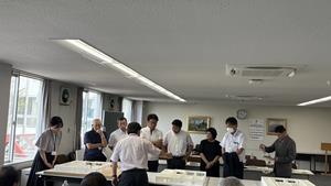 新学部校舎の模型を基に説明を受ける風景