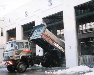 融雪槽に雪をダンプで投入してる写真